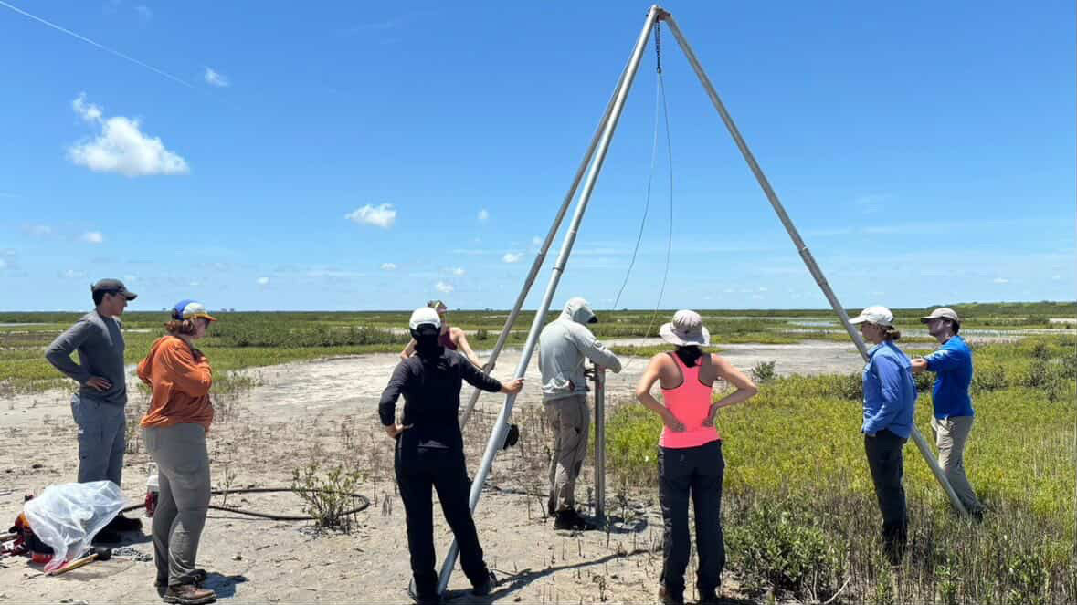 Chicas and fellow students prepare equipment to collect a sediment core.