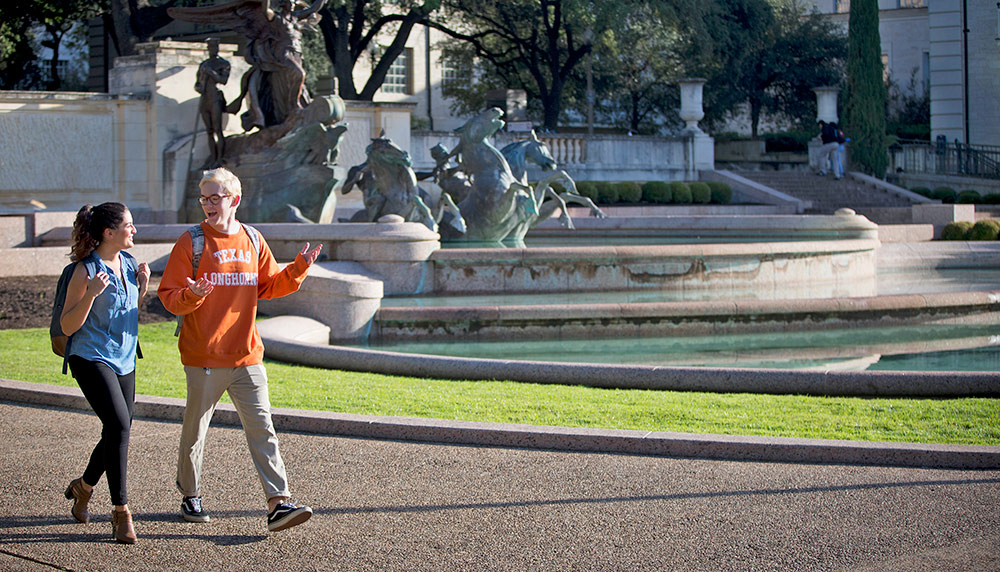 2 people walking on UT campus